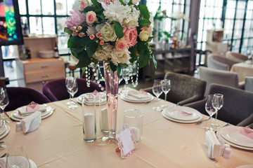 Square table served with white plates and candles