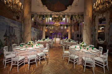 Round pink table with green glasses and white plates