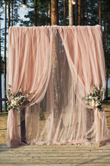Wedding altar made of pink cloth and roses