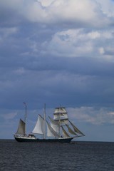 Fototapeta na wymiar Dreimaster unter vollem Segel auf der Ostsee mit Wolken am Himmel