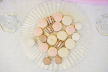 Pink and white macaroons on glass plate