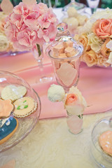 Glass bowls with pink sweets stand on the table