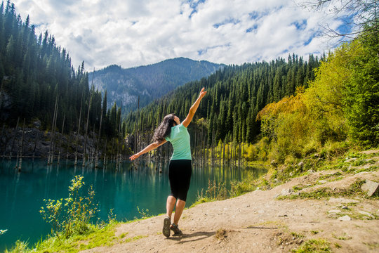Carefree Caucasian woman walking near lake 
