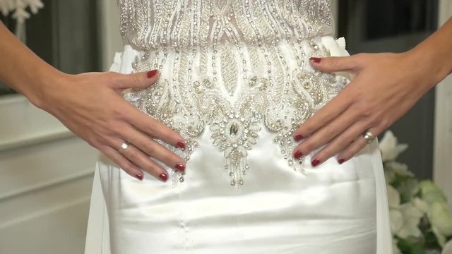 donna accarezza il proprio abito da sposa