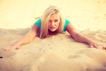 Woman lying on sandy beach relaxing during summer
