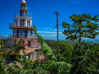 Roatan, Honduras Lighthouse building. Landscape of the island with a blue sky and green vegetation...