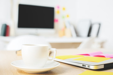 Closed laptop and coffee cup