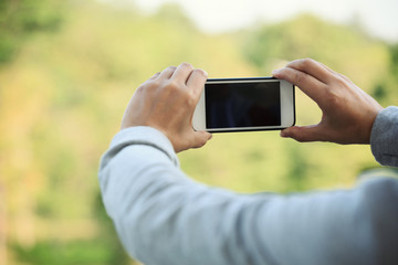 closeup of hands using smartphone taking photo outdoor