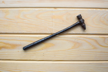 Old rusty hammer on wood background. Old rusty industrial home tools
