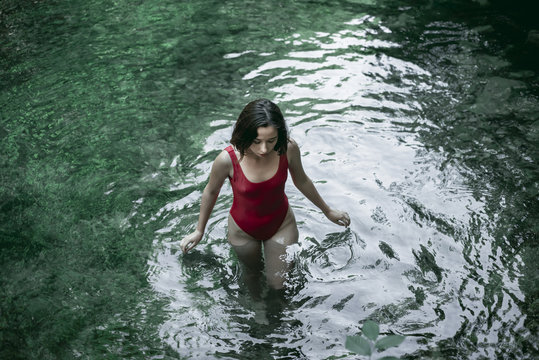 Woman in swimsuit wading in water