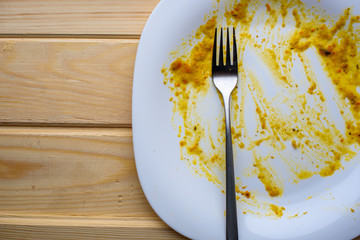 Dirty white dish on wood background, top view