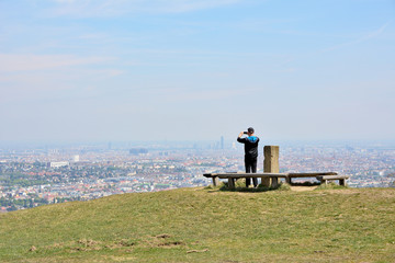 Obraz premium Anhöhe im Lainzer Tiergarten mit Blick auf Wien und fotografierendem Mann