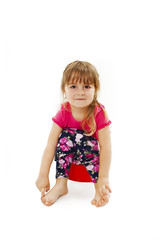 Little girl sitting on a chamber pot. Isolated on white background