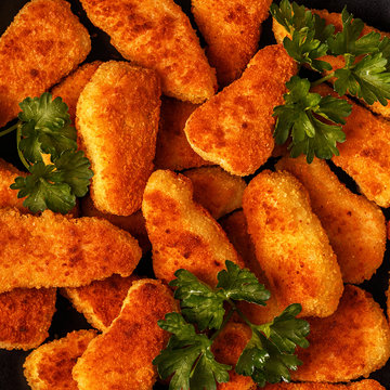 Chicken naggets with sauces on dark background.