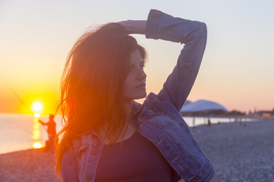Young attractive woman on the beach at sunset time