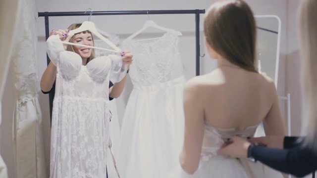 Young woman chooses a wedding dress in bridal shop