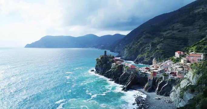 aerial view of travel landmark destination Vernazza, a small mediterranean sea town, Cinque terre National Park, Liguria, Italy. Afternoon sunny and cloud weather. 4k aerial drone side video shot