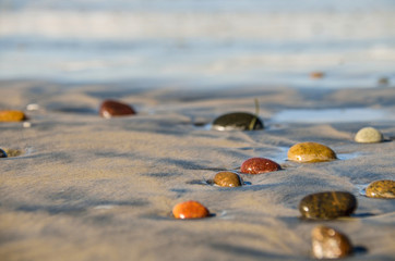 Pebbles stones on sand at the beach macro closeup