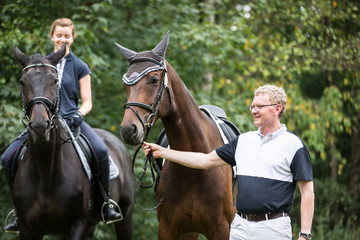 Adult Man And Girl With Their Horses