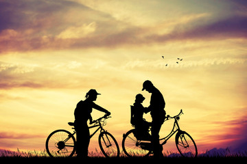 Obraz premium Family on bicycle at sunset