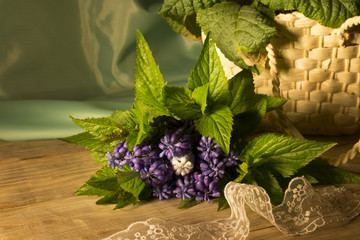 Bouquet of flowers and a wicker basket on a wooden background