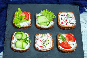Delicious canapes with vegetables. Cucumber, radishes, lettuce and lettuce. The concept of food and vegetarianism.