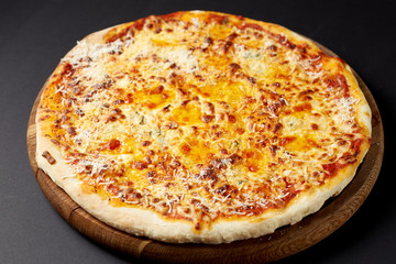 Hot pizza Quattro Formaggi on a rustic wooden table.