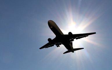 Fototapeta na wymiar Twin-engine jetliner silhouetted against the sun