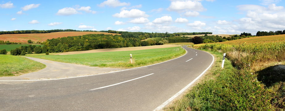 Strasse durch eine farbige Herbstlandschaft bei der Siedlung Maiermund im mittleren Hunsr&uuml;ck Panorama
