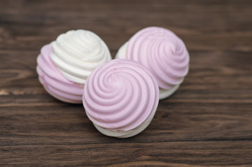 Sweet homemade dessert - berry marshmallow (zephyr) on a plain wooden background