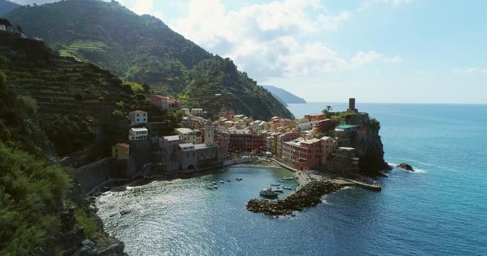 aerial view of travel landmark destination Vernazza, a small mediterranean sea town, Cinque terre National Park, Liguria, Italy. Morning sun and clouds. 4k slow motion 60 fps drone orbit video shot