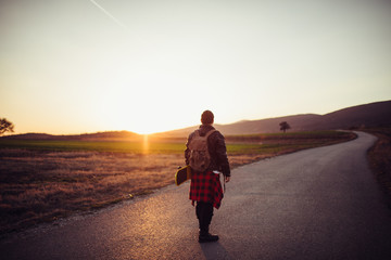 Skater man in sunset, rear view