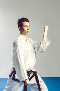 girl, Taekwondo is martial Stoke hands in fists, focused, serious look in the Studio on gray isolated background