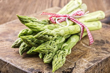 Grüner Spargel als close-up auf altem Schneidebrett