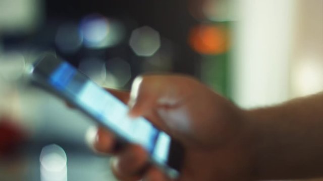 Using a Smartphone, sliding the screen and taping, close up shot with soft bokeh