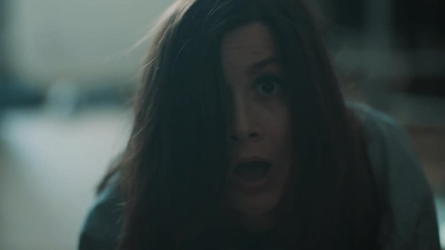 Young funny caucasian brunette girl get surprised and falls backward with open mouth in living room, close up slow motion