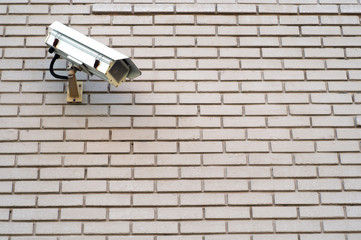security camera on gray bricks wall