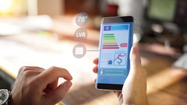 A Homeowner Uses A Home Controlling and Security Application on the smartphone 