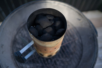 Grillkohle liegt im Anzündkamin. Die Sicht von oben.