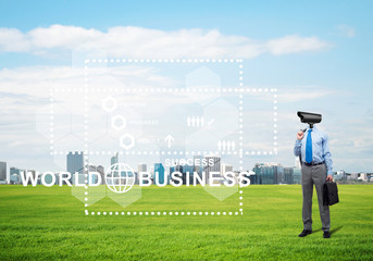 Camera headed man standing on green grass against modern cityscape