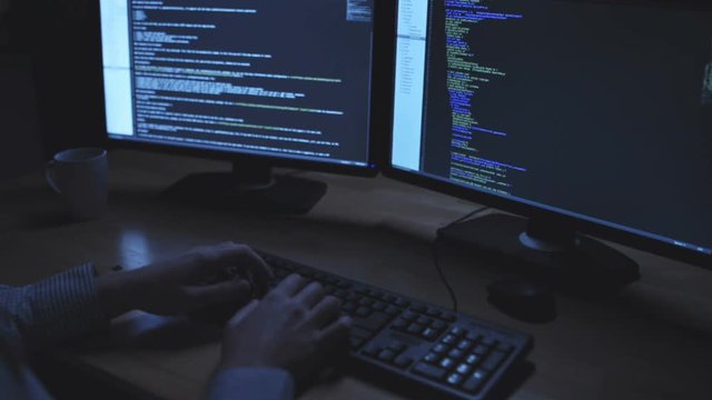Concentrated IT man hacking at night