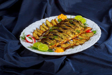 Grilled baked fish with potatoes in the oven
