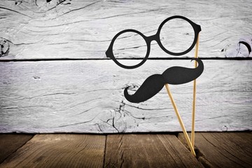 Funny mustache and glasses on sticks against a rustic white wood background - Powered by Adobe