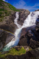 Rainbow and waterfall in the mountains valley in Norway