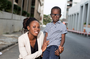 Young woman carrying her son on her knee and take a picture with him.