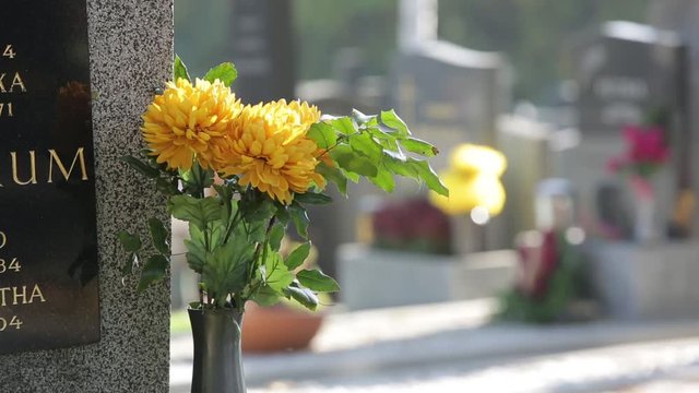 Cemetery in spring with flowers, wreaths and gravestones - 7