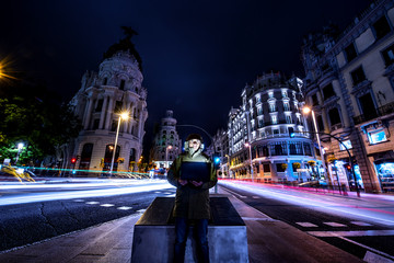 Man with computer Gran Via Madrid long exposure.