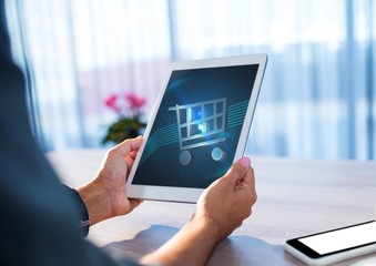Person using Tablet with Shopping trolley icon