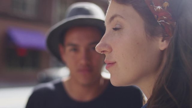 A young couple standing together on a city street, close up