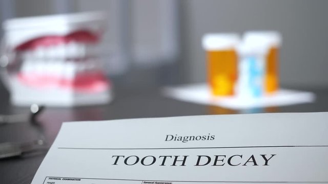 Focus pull on a tooth decay dental diagnostic sitting on dentist's desk.